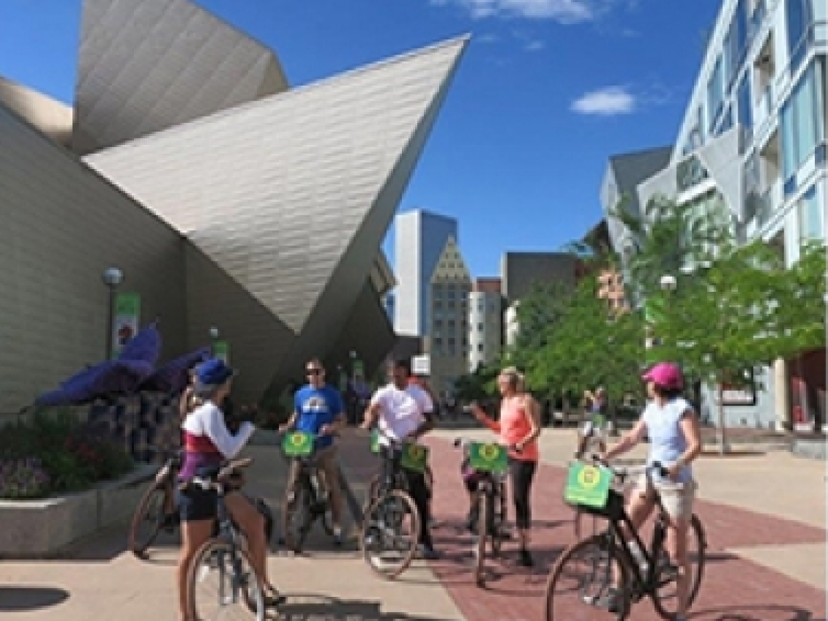 a group of people riding on the back of a bicycle