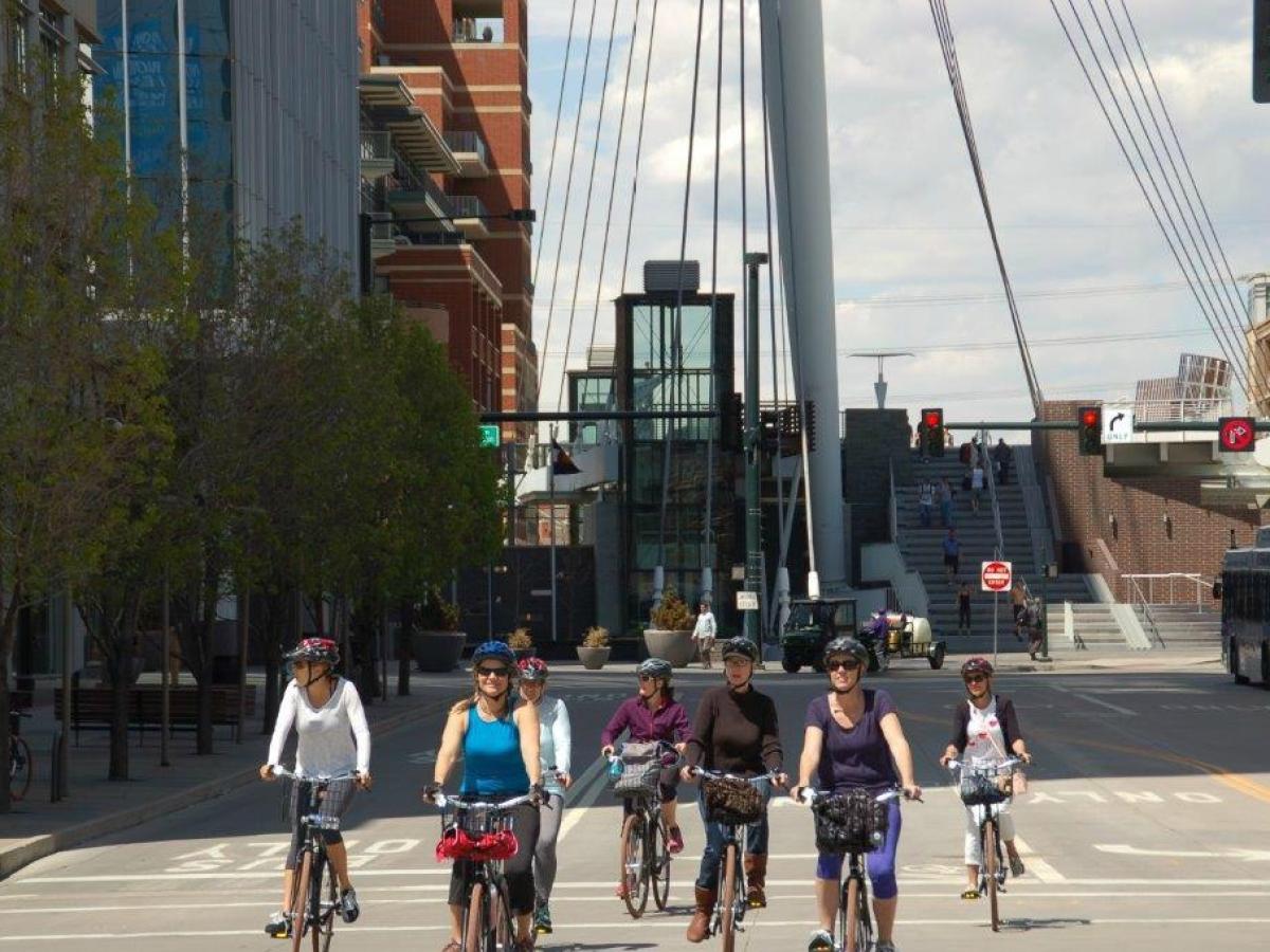 a group of people riding bikes on a city street